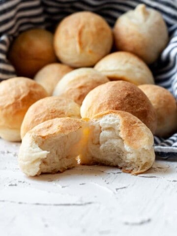 a bowl of rolls tipped over. One is torn open