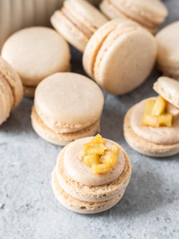 An opened french macaron with apple pie spice american buttercream and apple pie filling