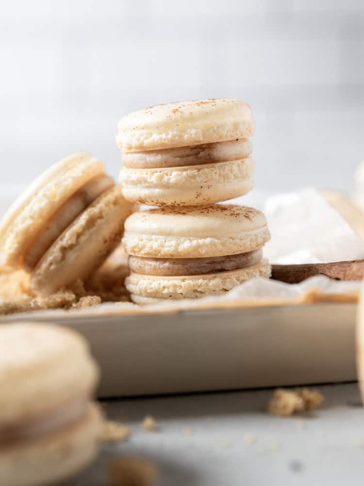 two cinnamon roll macarons stacked on top of each other