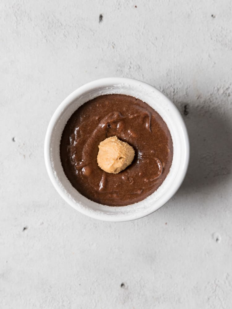 A ramekin filled with the chocolate mixture with a ball of peanut butter on top