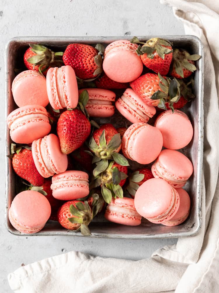 A tray of fresh strawberries and macarons