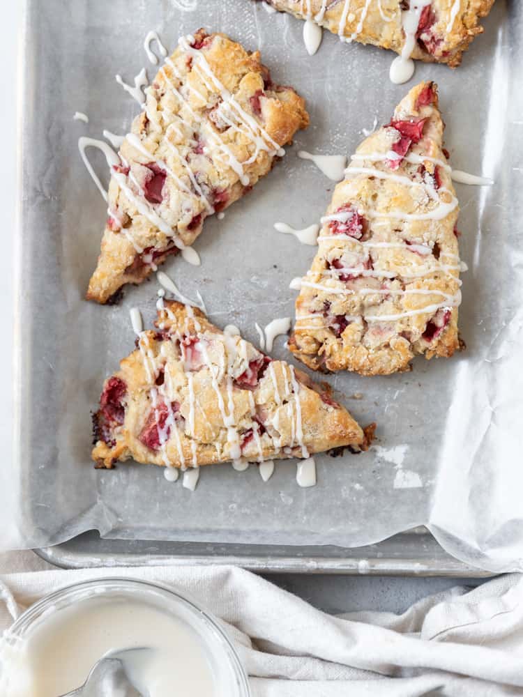 Looking down on a sheet pan of strawberry and cream scones