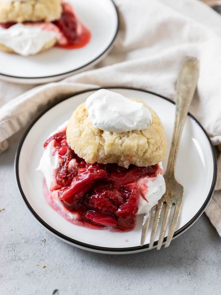 A strawberry shortcake topped with a dollop of fresh whipped cream