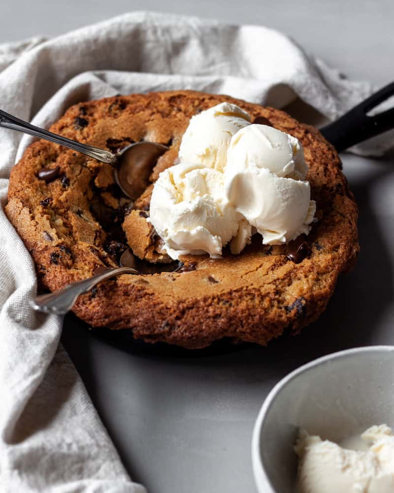 A stuffed skillet cookie with scoops taken out of it
