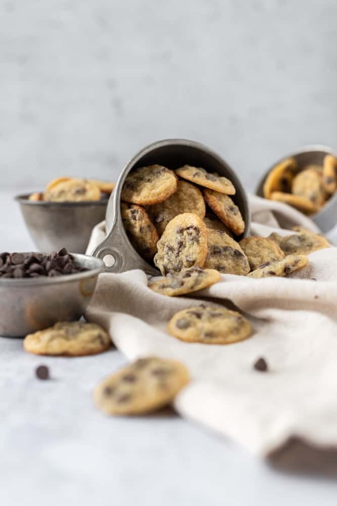 A small cup of mini chocolate chip cookies tipped over