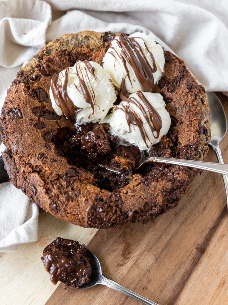 A skillet cookie with scoops taken out of it