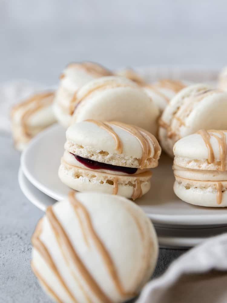 A peanut butter and jelly macaron will some jelly coming out of the middle