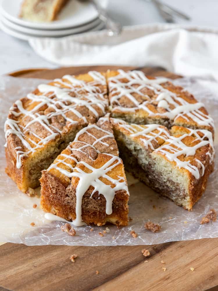 A coffee cake that is topped with maple glaze and missing a slice
