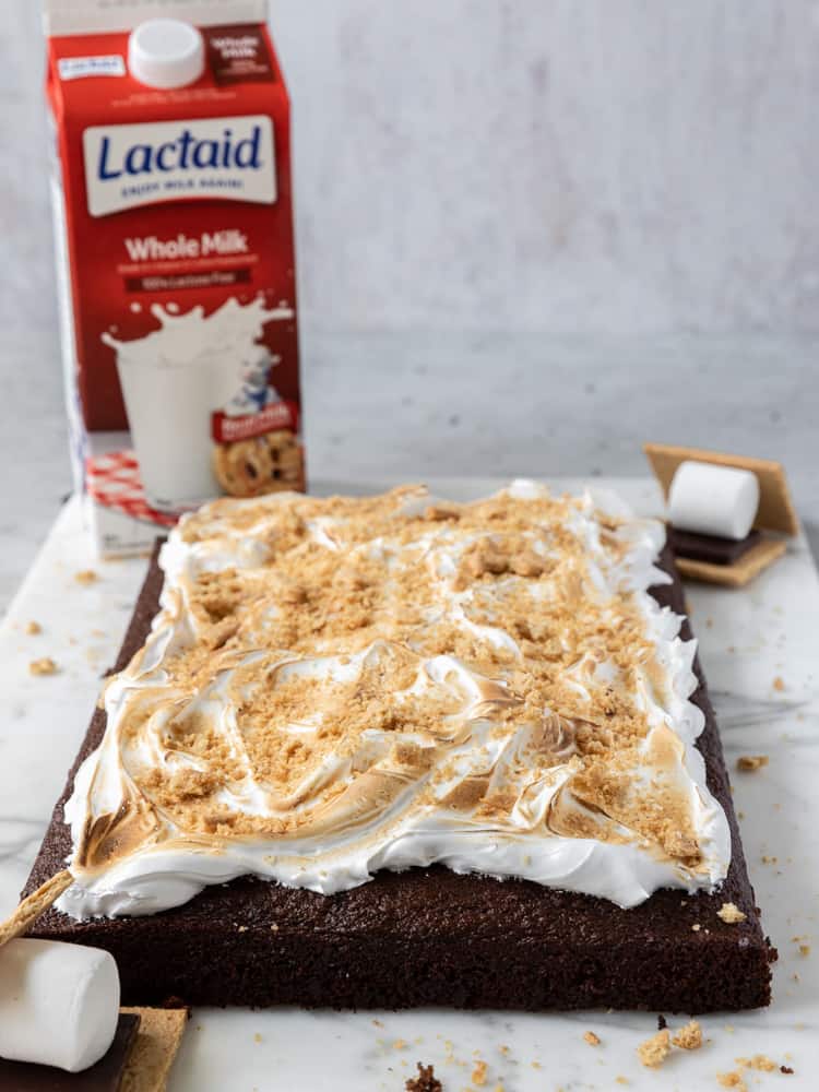 A s'mores sheet cake topped with toasted marshmallow frosting and graham cracker crumbles.