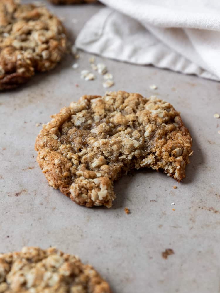 A close up of an oatmeal cookie with a bite out of it