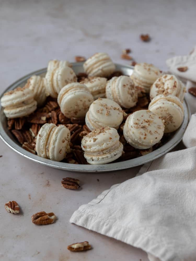A pie dish filled with pecans and french macarons