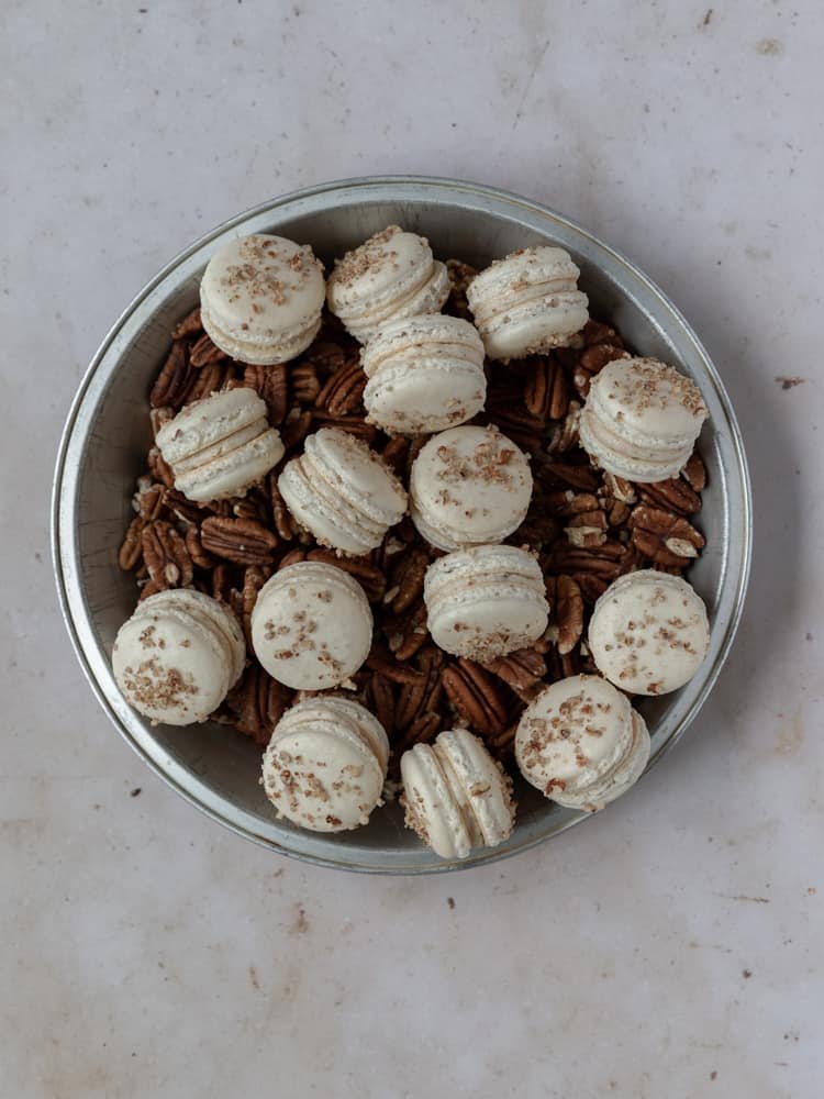 pecan macarons and pecans in a dish
