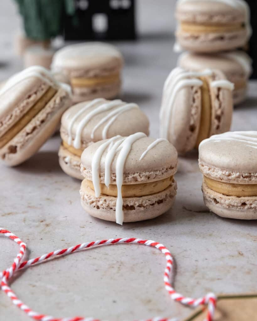 A closeup of a macaron flavored with gingerbread spices and filled with a molasses buttercream