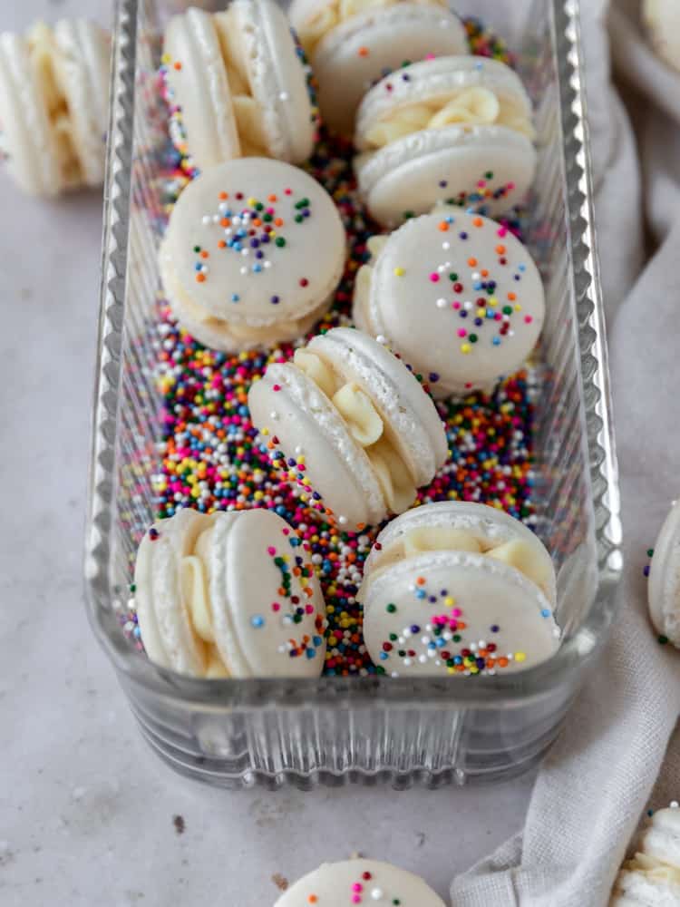 a dish full of sprinkles and french macarons