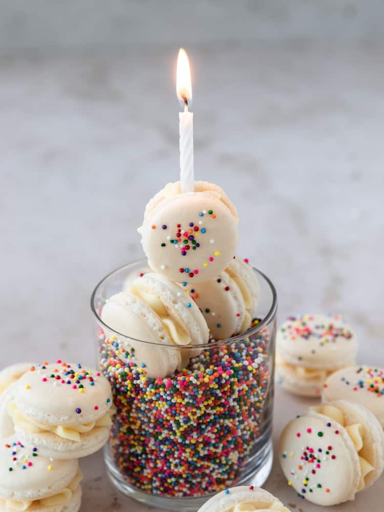 a birthday cake macaron with a birthday candle on top