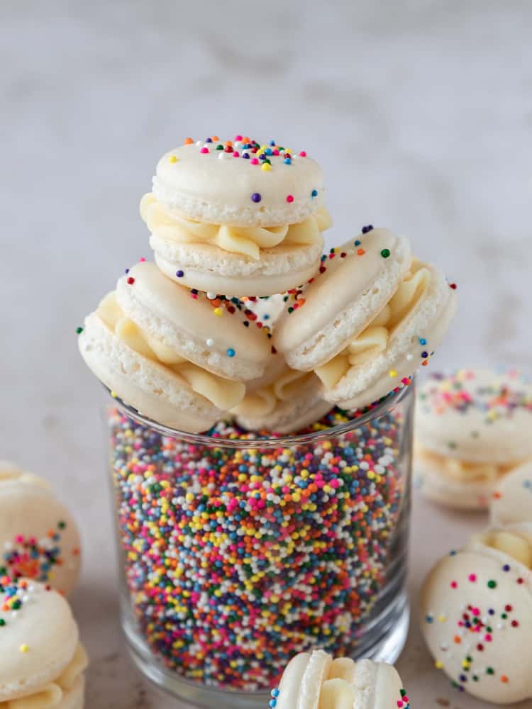 A cup filled with sprinkles and macarons