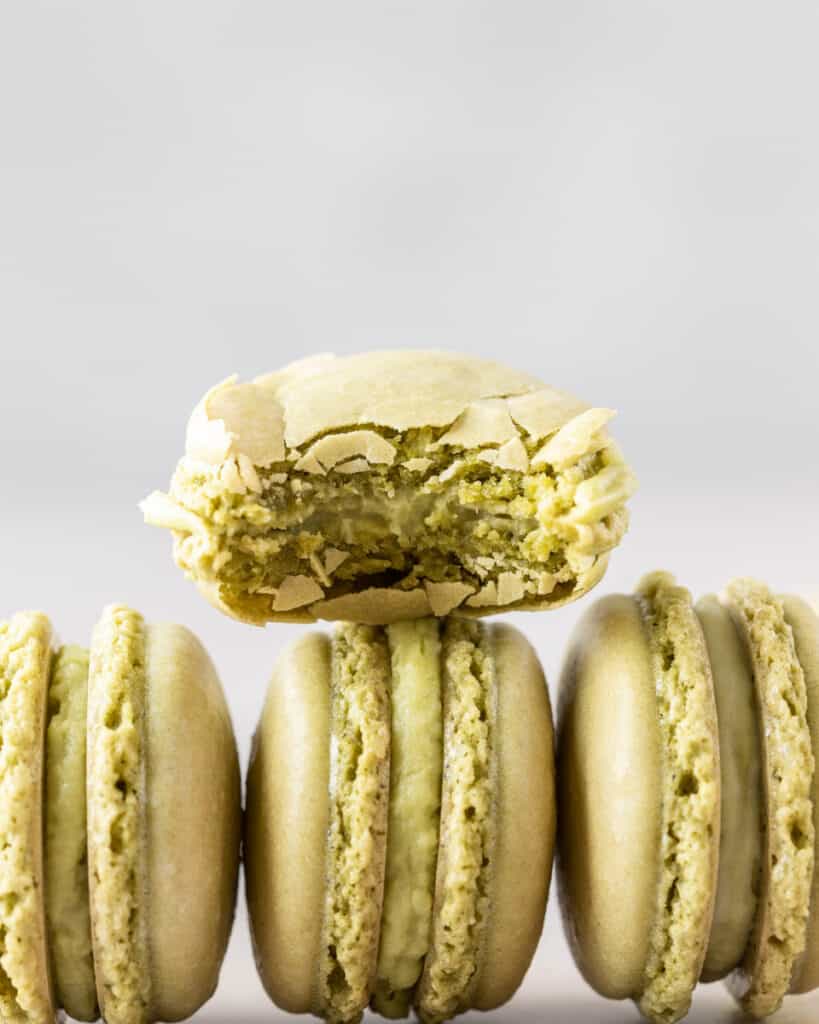 a french macaron with a bite out of it stacked on top of other macarons