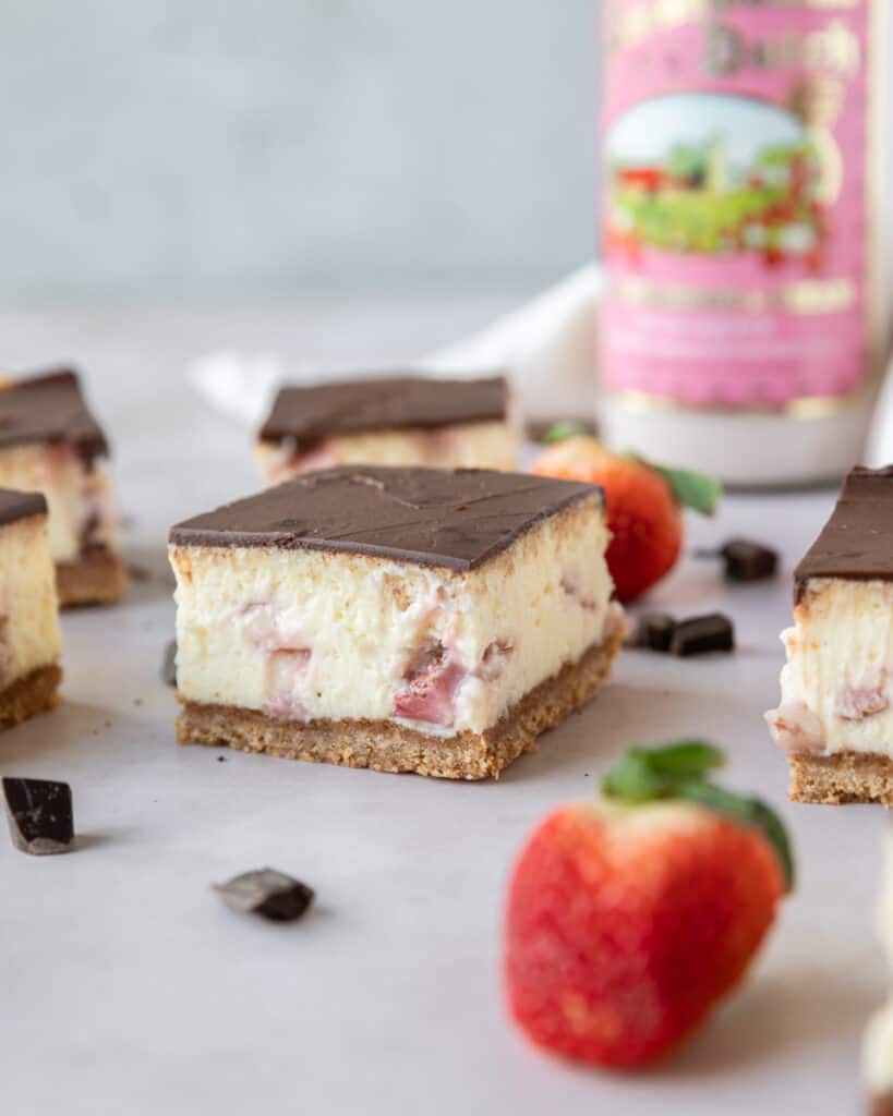 chocolate covered strawberry cheesecake bars on a board