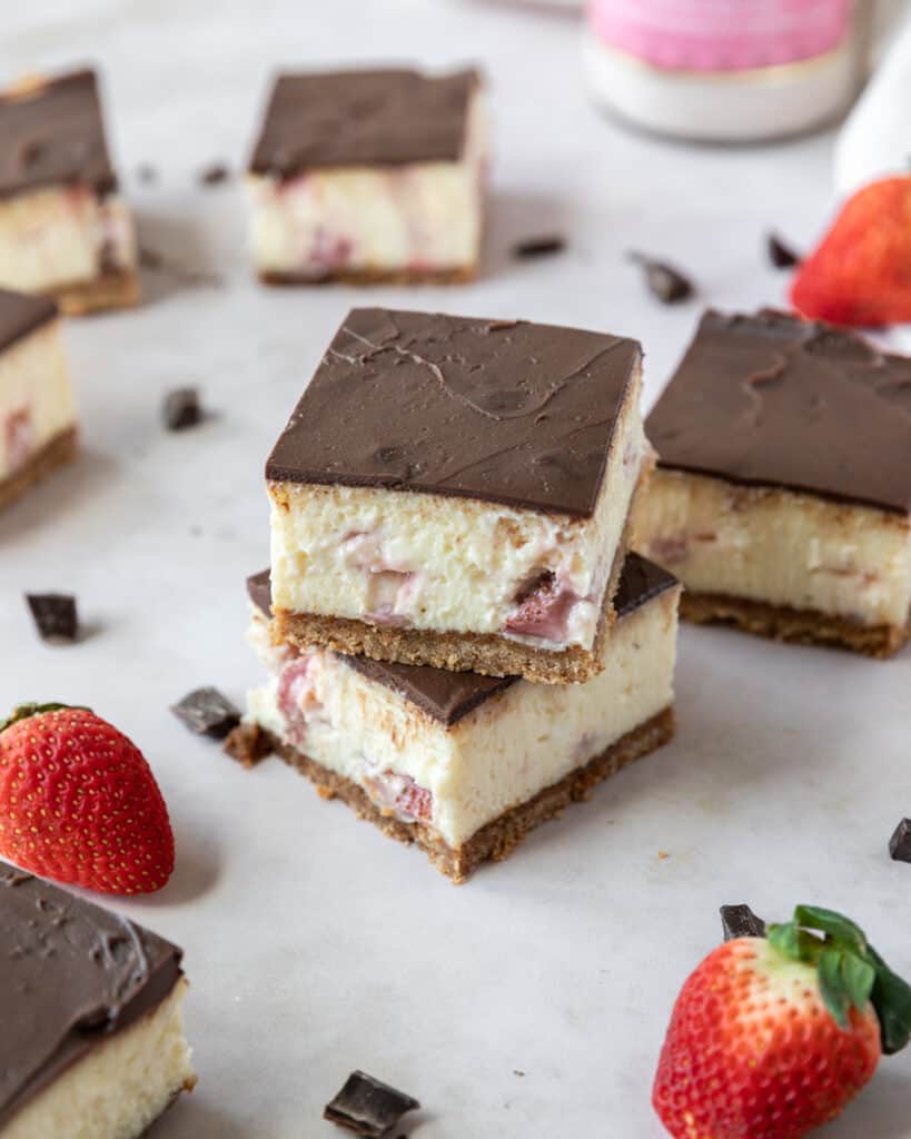 two chocolate covered strawberry cheesecake bars stacked on top of each other