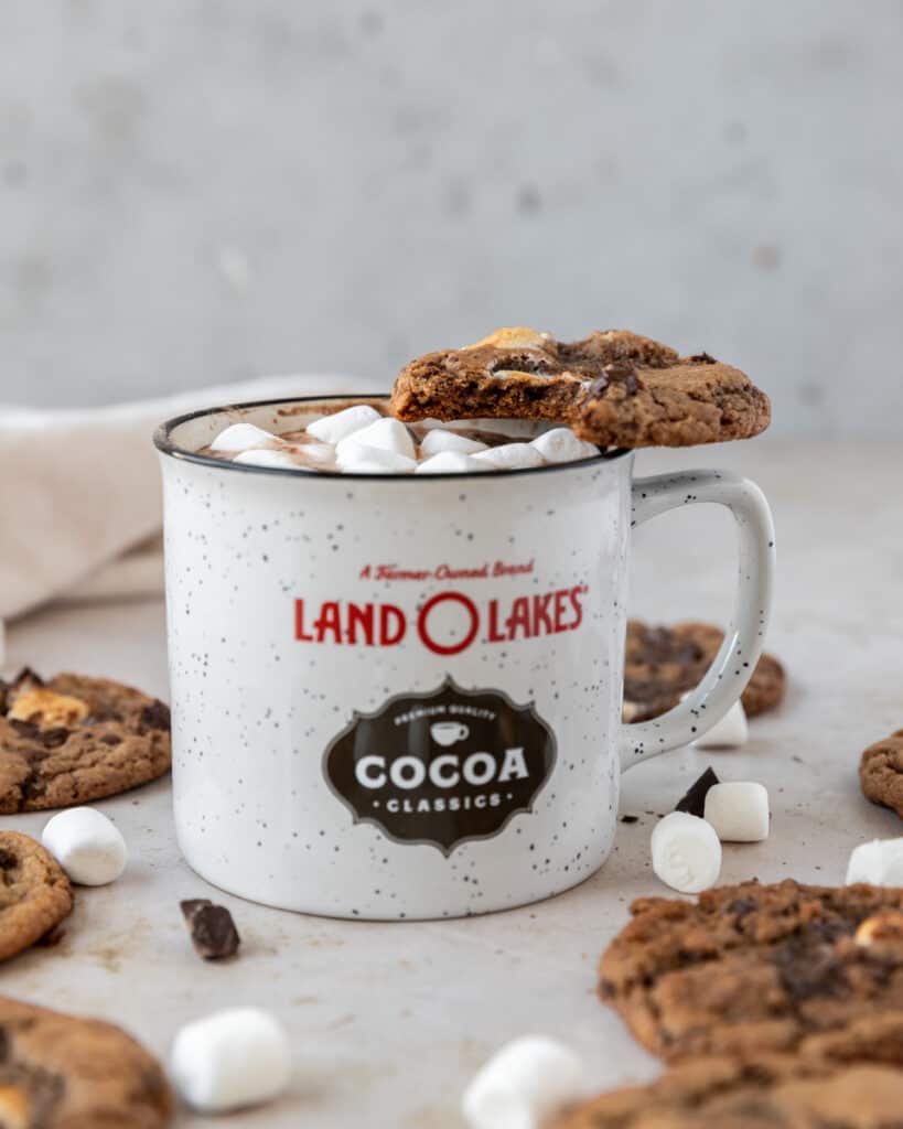 a hot cocoa cookie balanced on a cup of hot cocoa