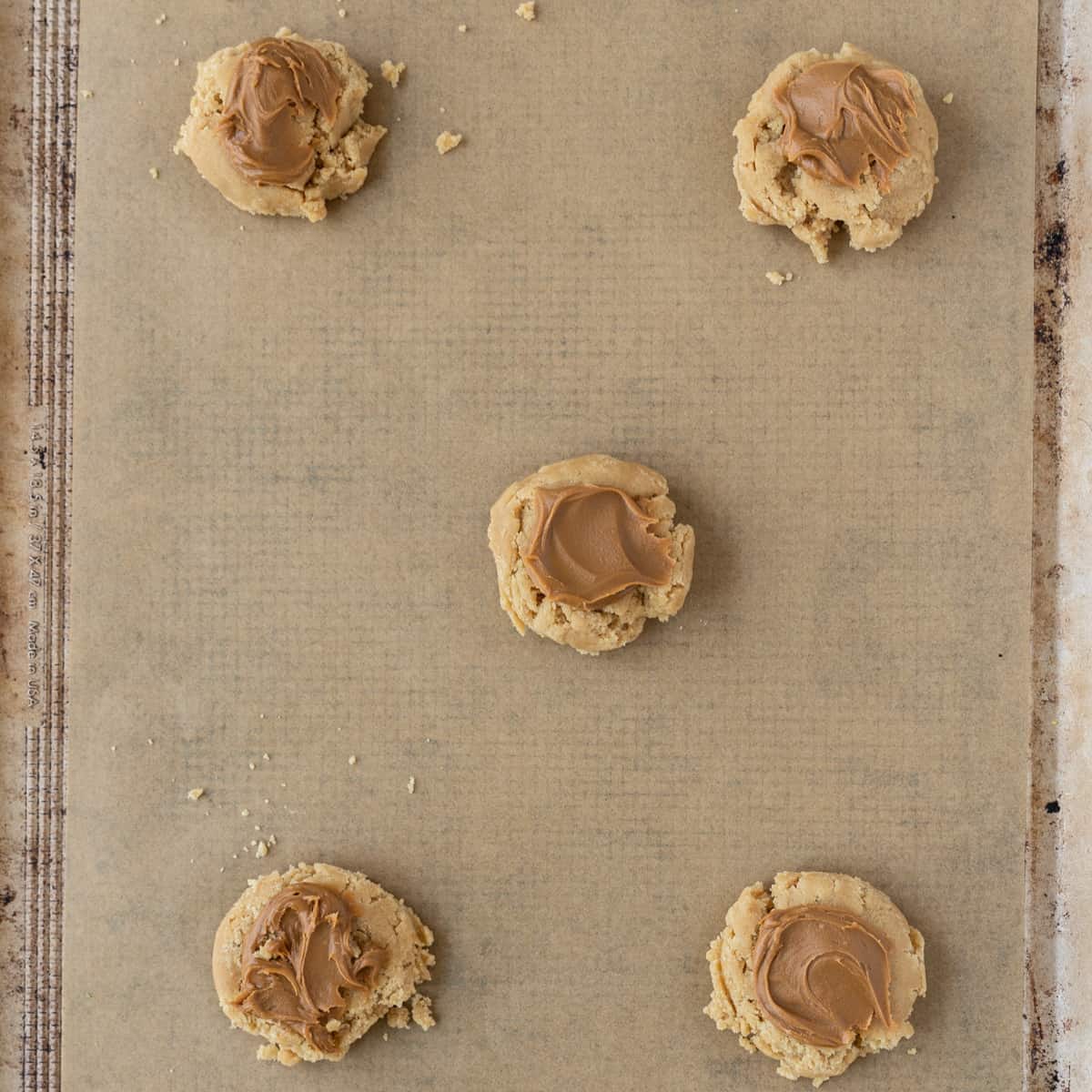the unbaked cookie dough swirled with biscoff butter on a prepared cookie sheet