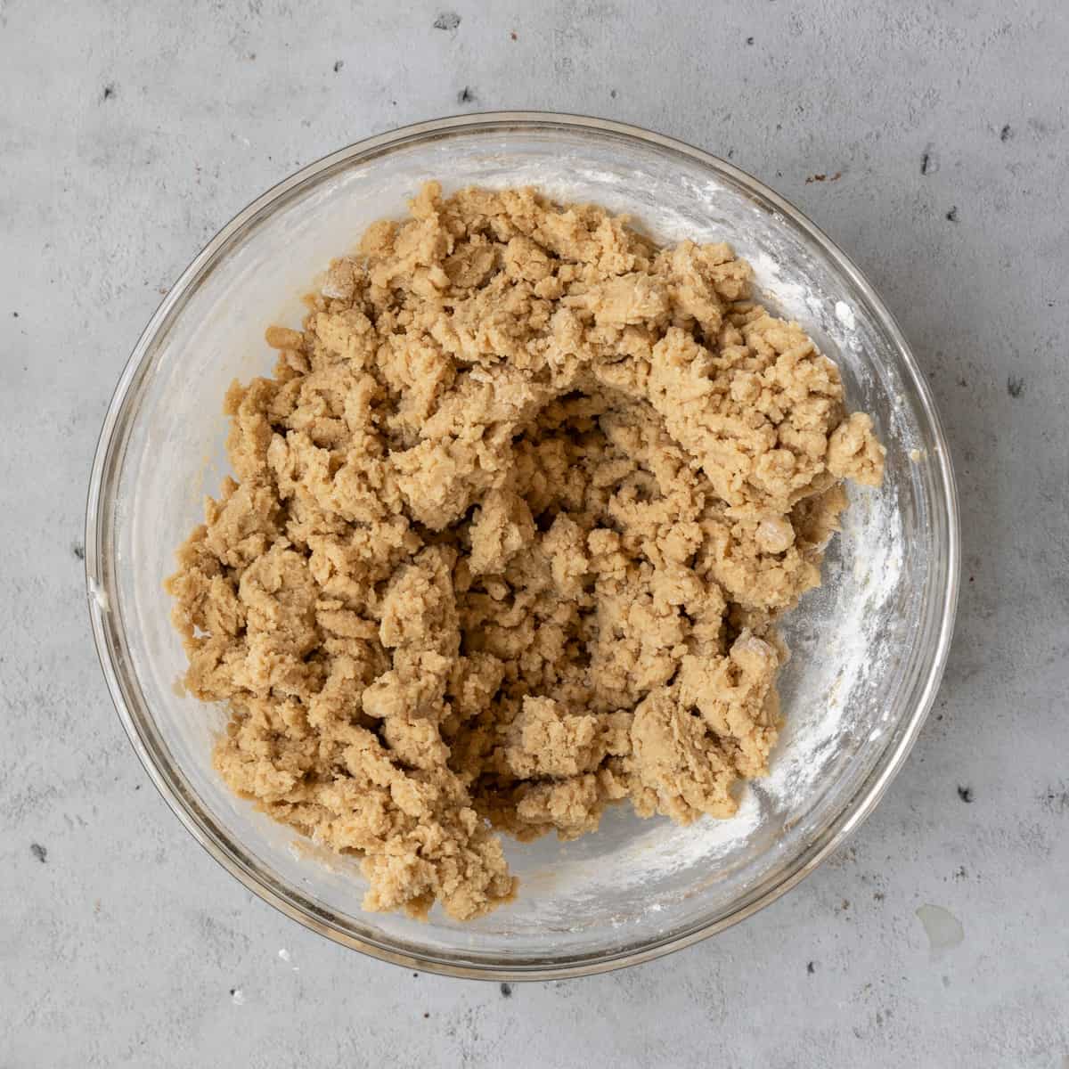 the completed cookie dough in a glass bowl on a grey background