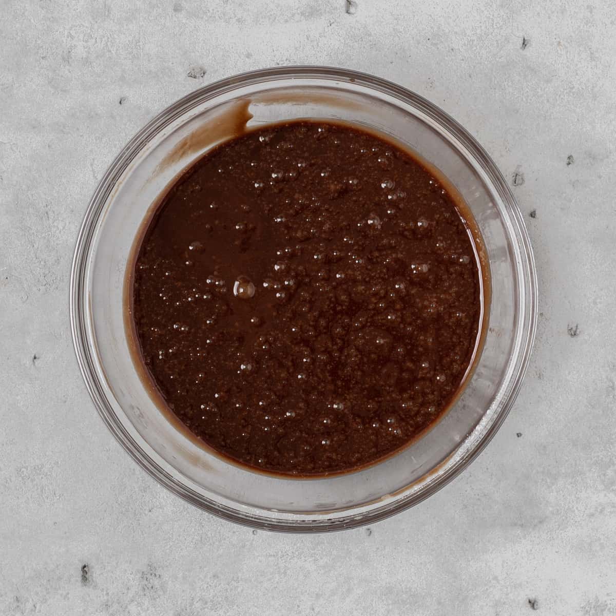 the completed lava cake batter in a glass bowl on a grey background.