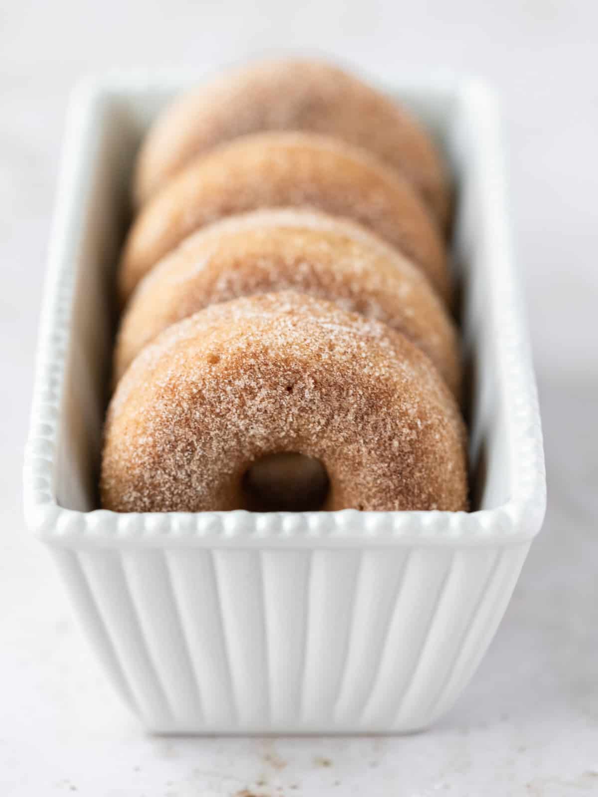 cinnamon sugar donuts lined up in a white dish