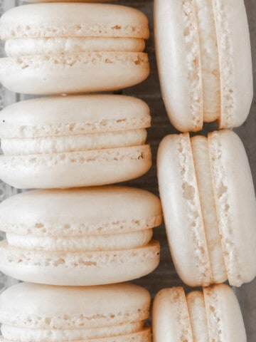 a close-up shot of two rows of french macarons in a glass dish