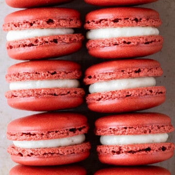 two rows of red velvet macarons on a tan background