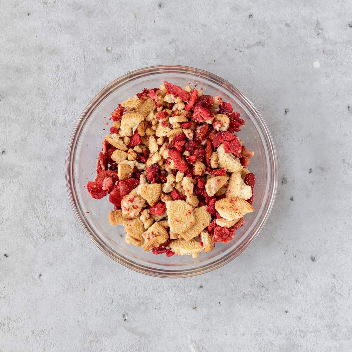 the strawberry crunch in a glass bowl on a grey background