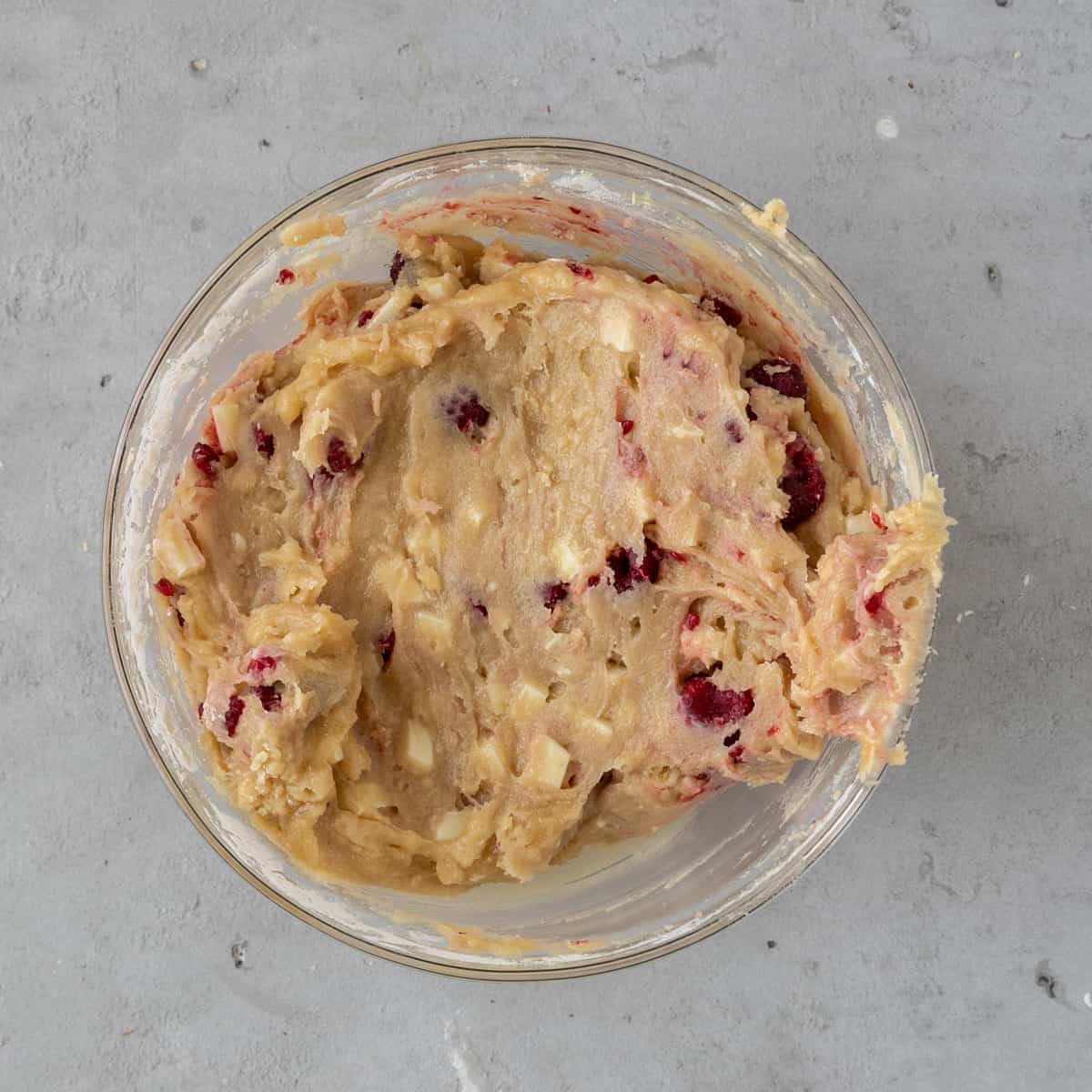 the completed blondie batter in a glass bowl on a grey background