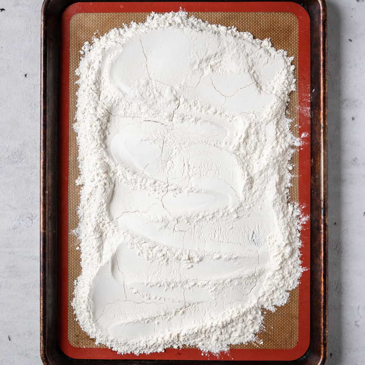 the flour spread out on a baking sheet before being baked.