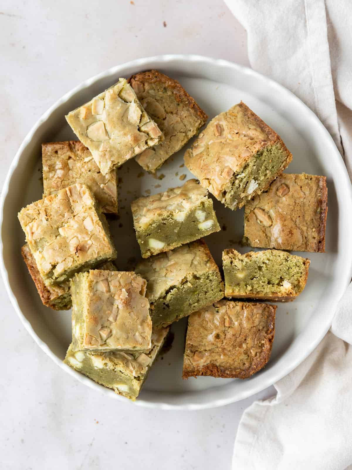 a white dish full of matcha brownies.