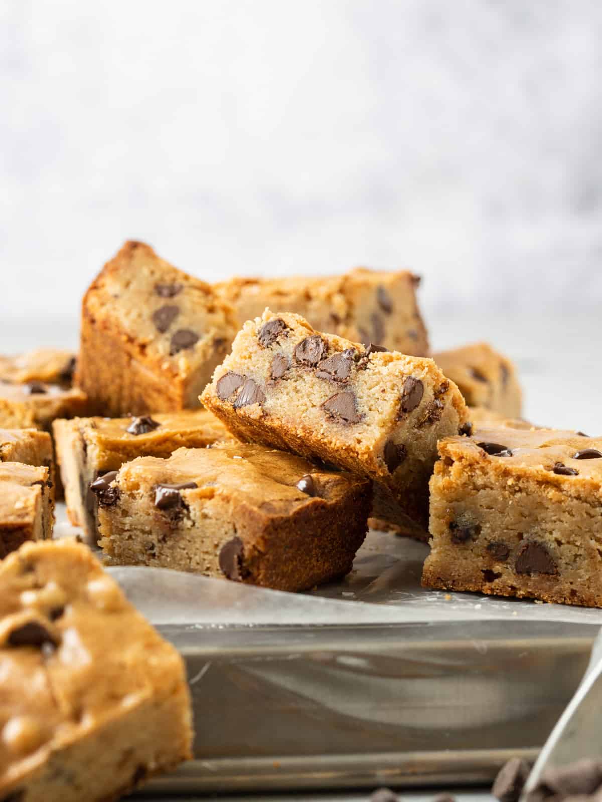 a stack of brown butter blondies on a metal tray.