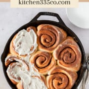 looking down on a cast iron pan filled with caramel cinnamon rolls. half of them are topped with brown butter icing. It says caramel cinnamon rolls across the top.