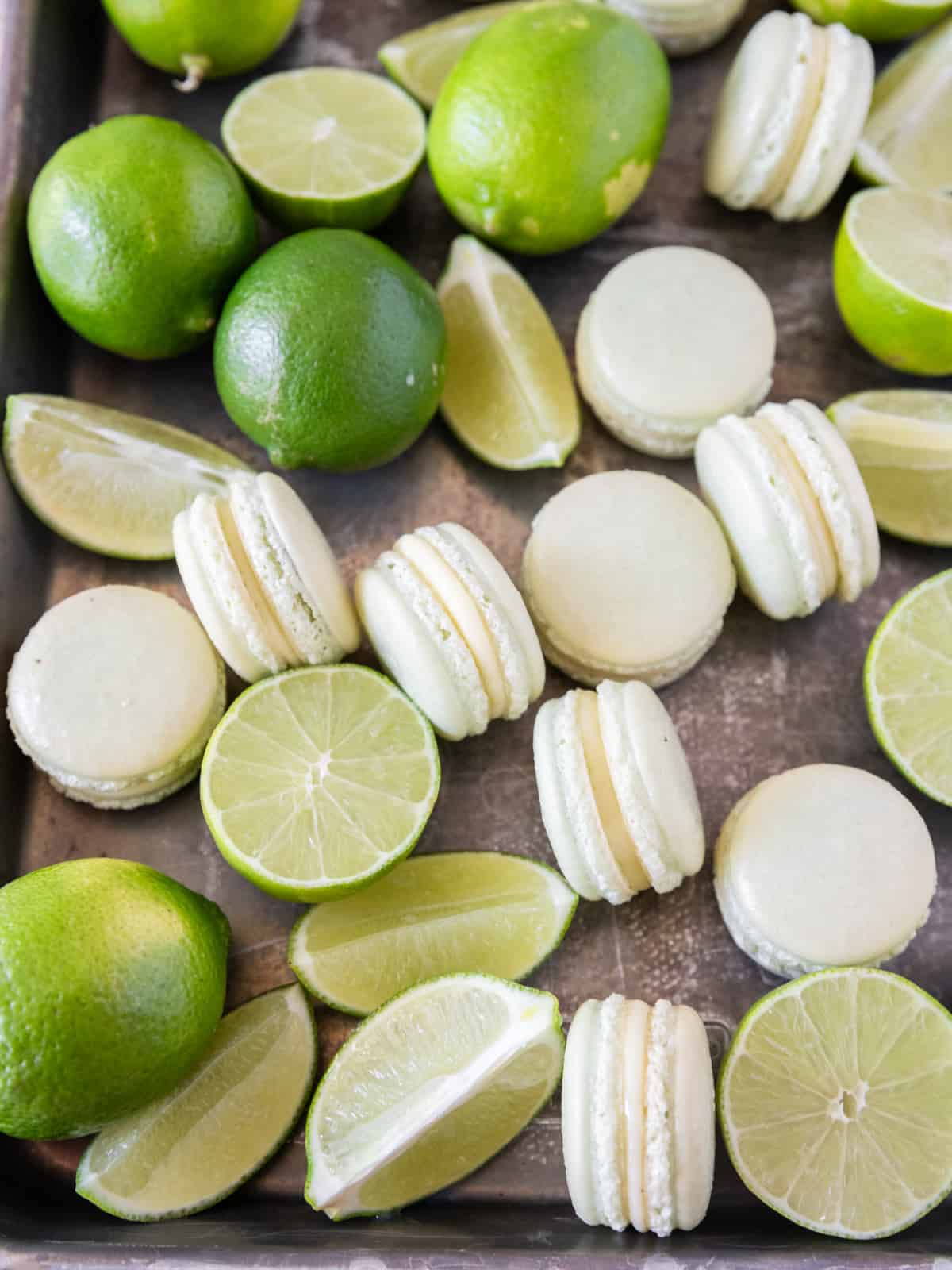 a sheet pan full of key lime macarons and key limes.