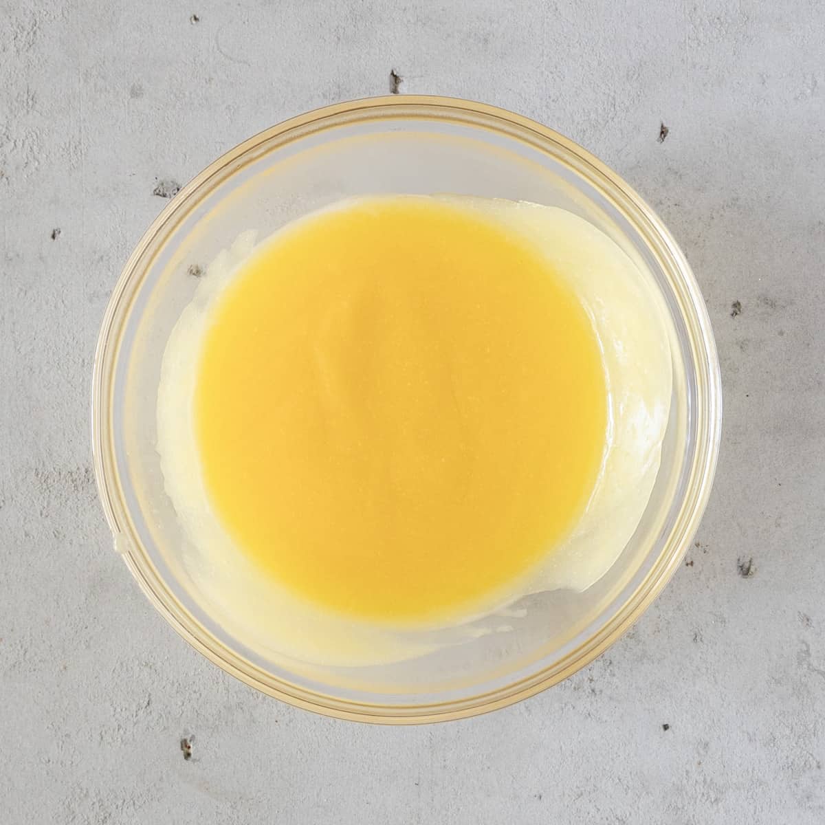 the lime curd in a glass bowl on a grey background.