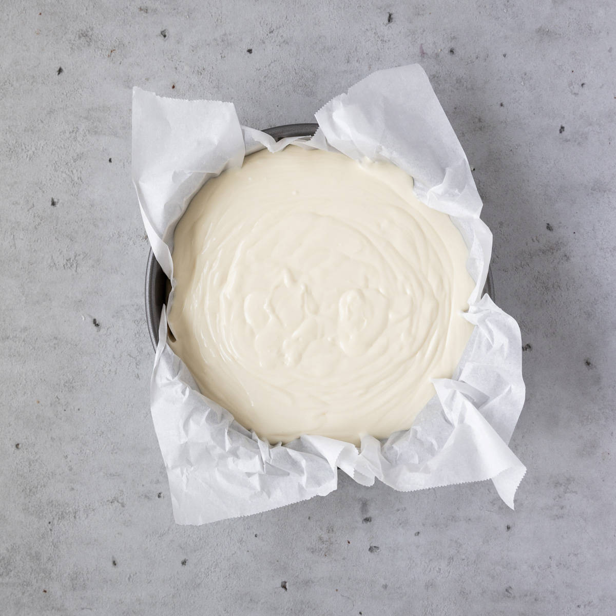 the cheesecake in a spring form pan lined with parchment paper before being baked.