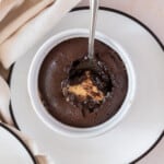 a peanut butter lava cake with a spoon in it taking a scoop out on white plate.