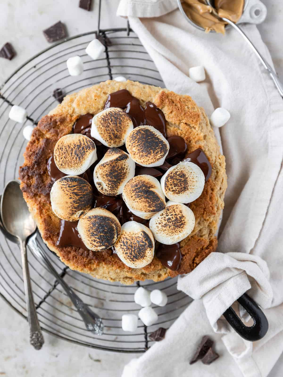a peanut butter s'mores skillet cookie surrounded by mini marshmallows and chunks of chocolate.