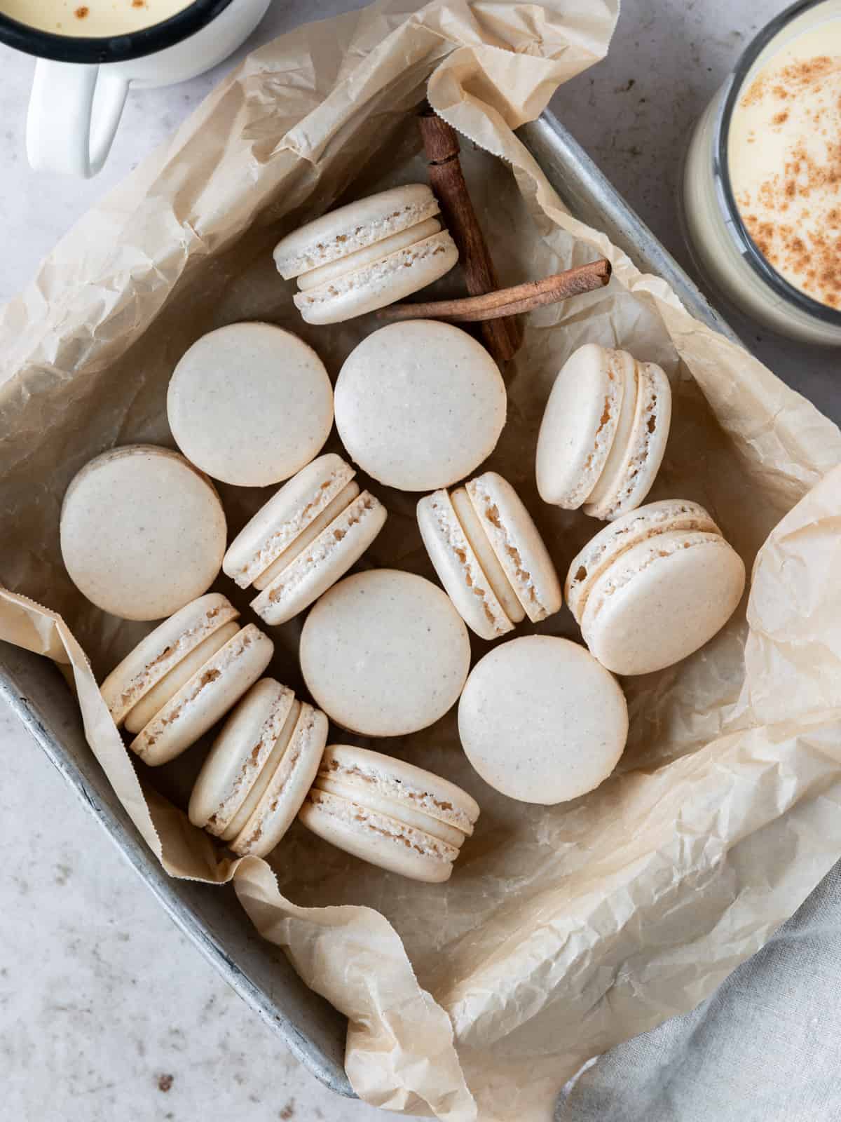eggnog macarons in a parchment lined metal baking dish.