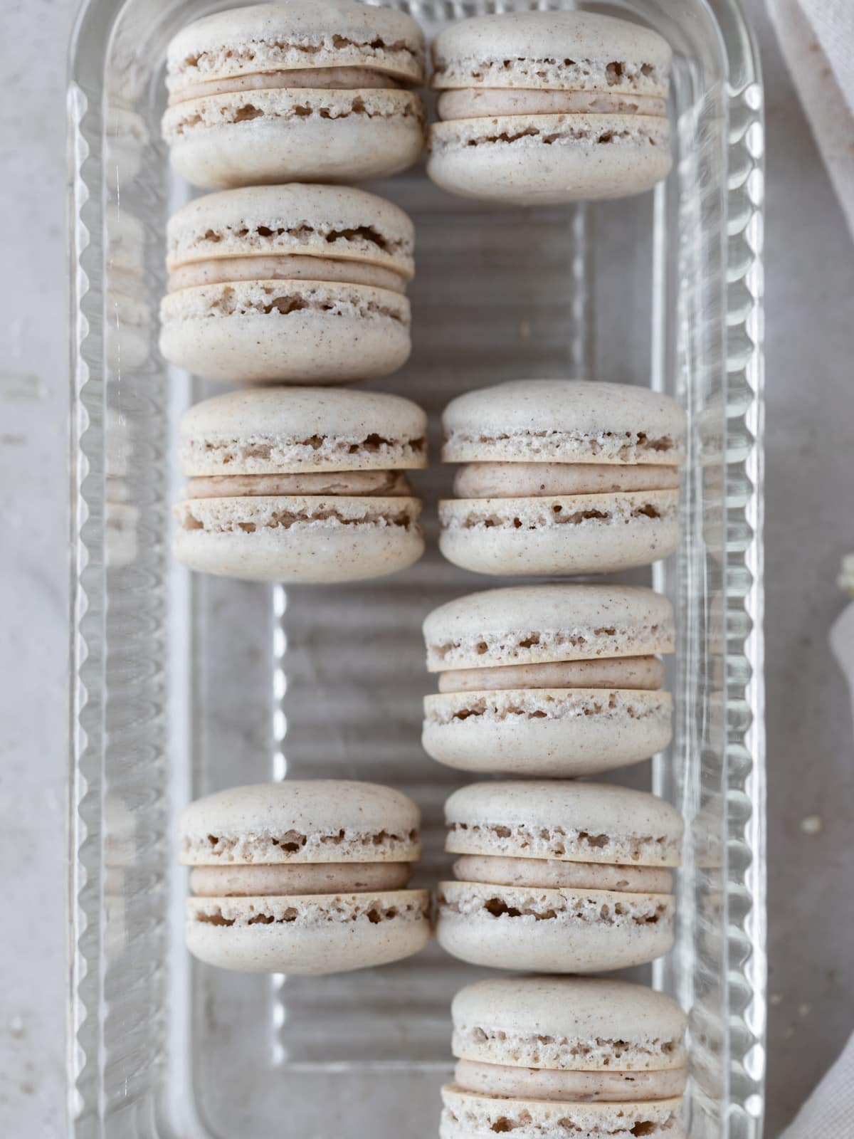 several pumpkin spice macarons placed with spaces in a glass dish.
