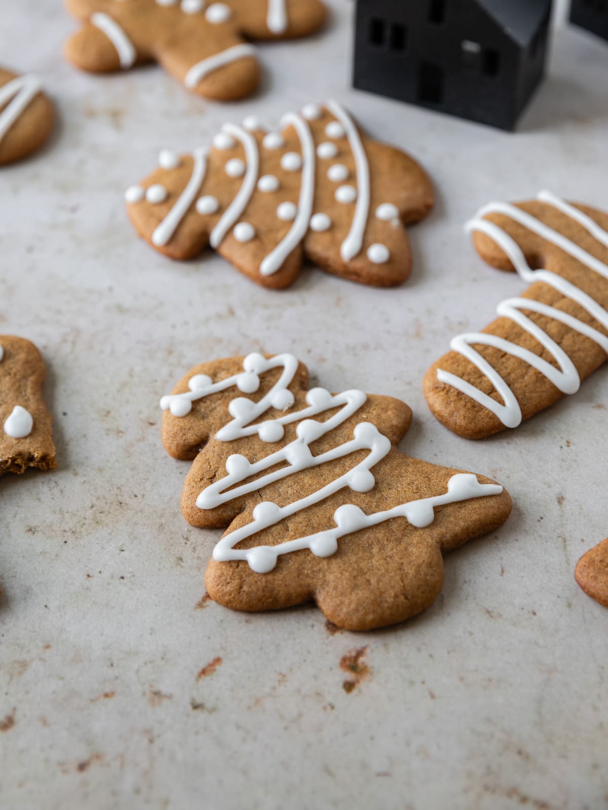 a soft gingerbread cookie topped with icing and surrounded by other cookies.