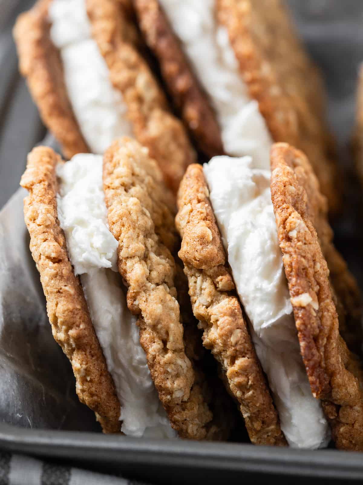 two oatmeal cream pies leaning up against the side of a metal pan.
