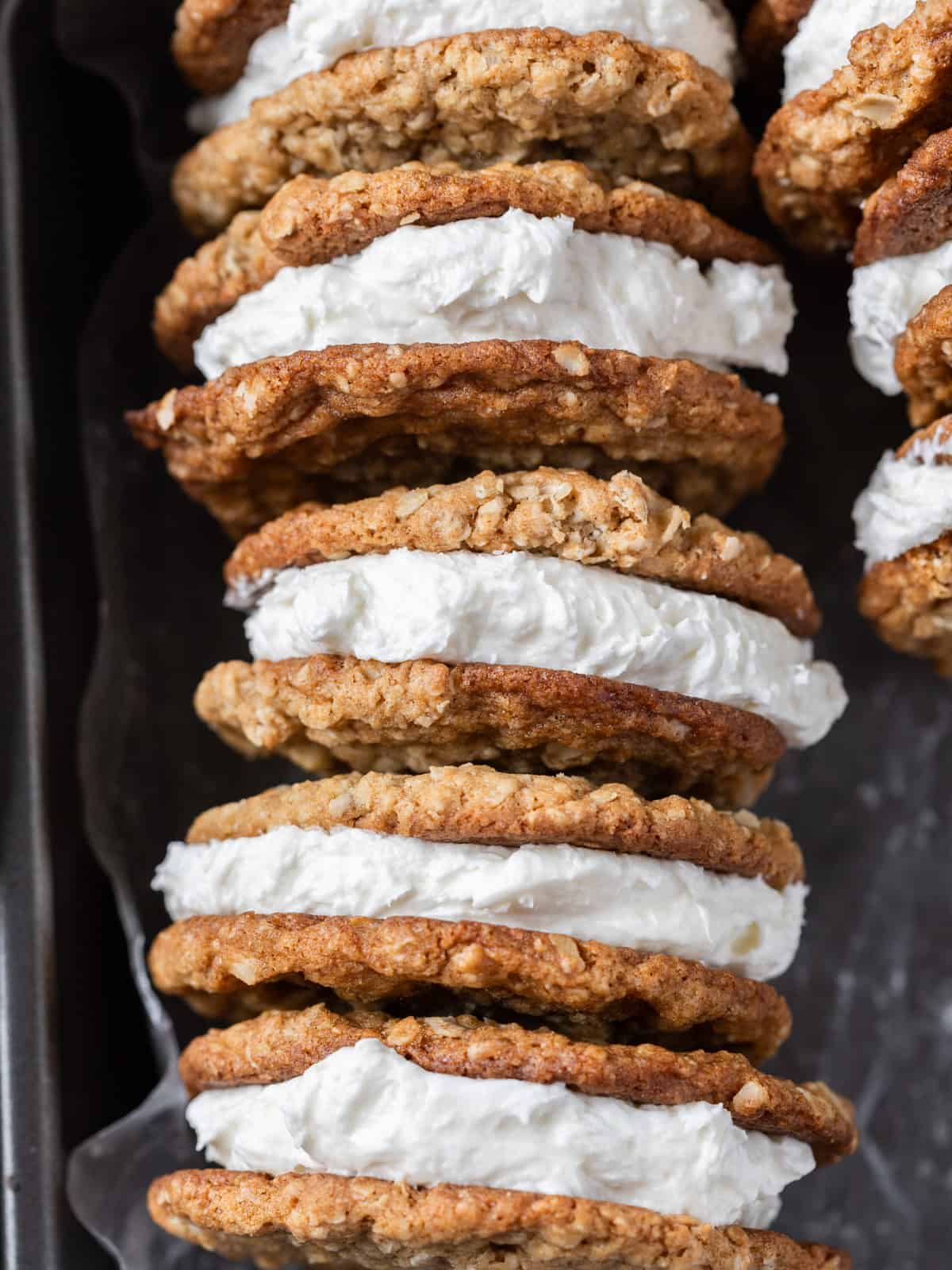 a row of oatmeal cream pies in a metal baking pan.