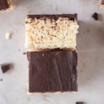 a chocolate covered rice krispie treat on its side leaning on another treat.
