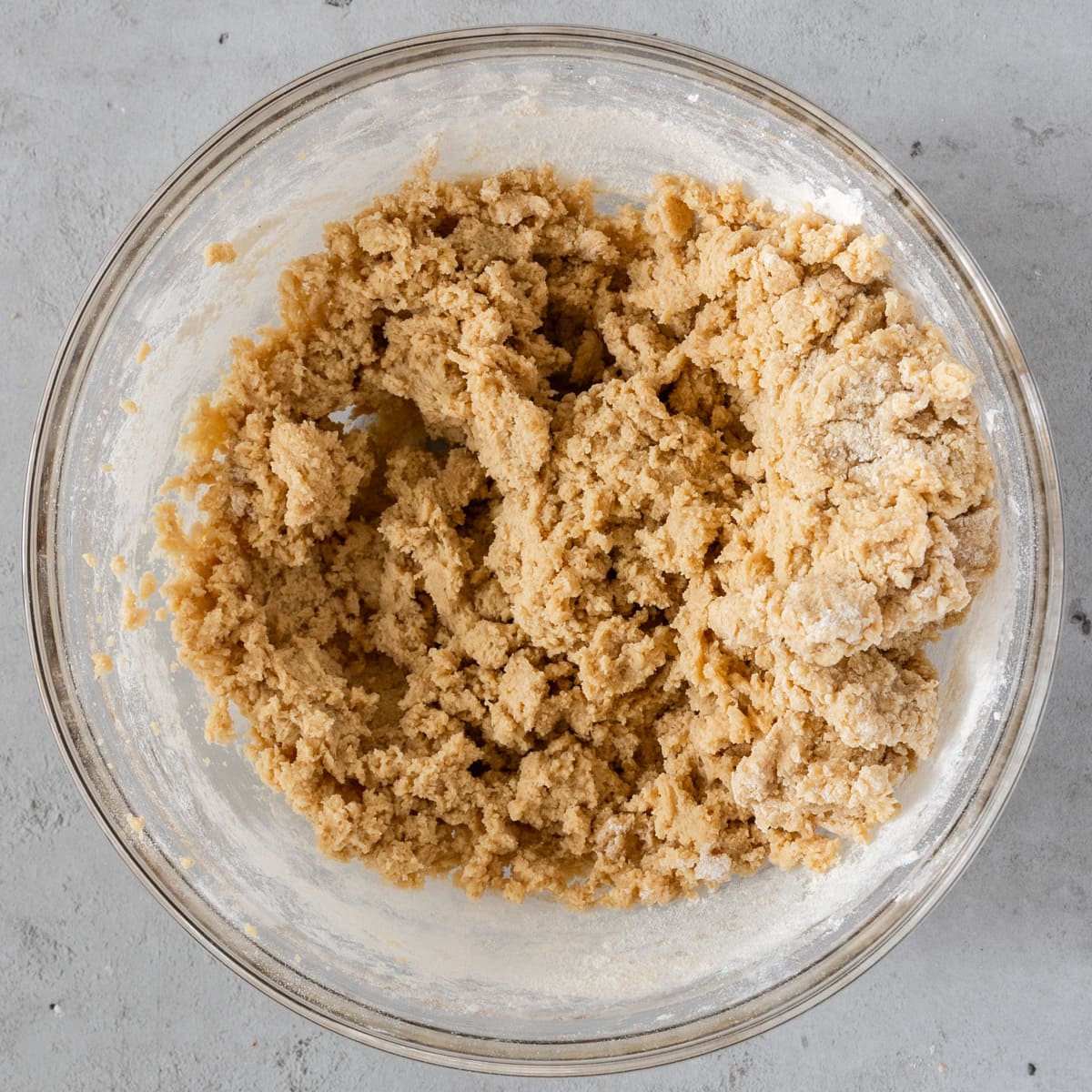 the wet and dry ingredients combined in a glass bowl on a grey background.