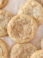 a pile of pumpkin pie spice cookies on a piece of parchment paper.
