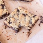 a chocolate chip cookie bar with a bite out of it surrounded by other cookie bars.